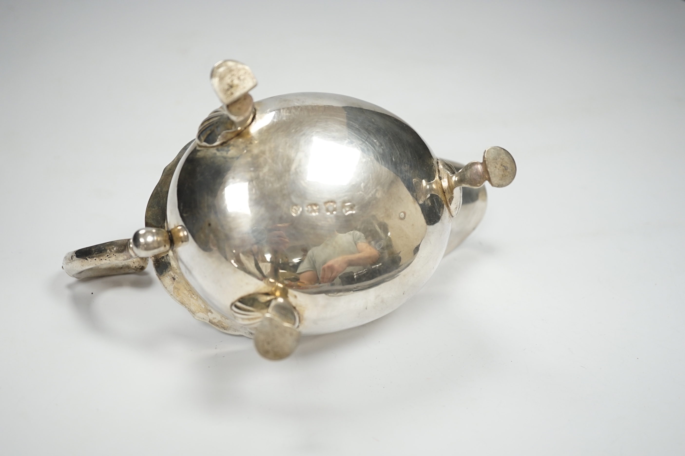 A George II silver sauceboat, with flying scroll handle, John Pollock, London, 1751, length 21cm, 12oz.
